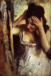 woman combing her hair in front of a mirror